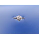 A diamond daisy cluster ring in '18ct & Pt'. Finger size N.