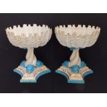 A pair of 19thC Royal Worcester porcelain circular shell-shaped bowls on triform pedestal dolphin
