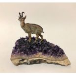A cold painted bronze study of a chamois goat modelled astride a large specimen of mineral amethyst,