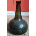 An 18thC onion shaped green glass bottle,