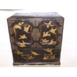 A late 19thC Japanese lacquered table cabinet decorated overall with gilt birds against a self-
