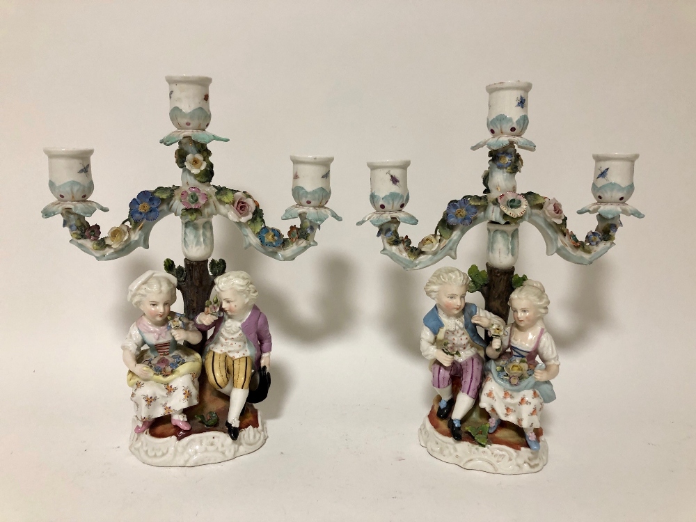 A pair of late 19thC Meissen style porcelain twin branch figural candelabra, underglaze blue scissor