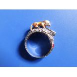 A '14' yellow metal ring modelled with a lion gazing into a red enamelled pool. Finger size N.