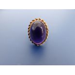 An oval cabochon amethyst set 9ct gold ring. Finger size K/L.