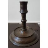 An antique Islamic copper alloy candlestick, decorated overall with stylised foliate decoration