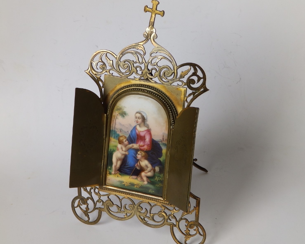 A late 19thC Italian gilt brass framed devotional porcelain panel, two hinged doors revealing an