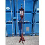 An Arts & Crafts style stained wood 'street lamp' standard lamp.