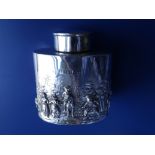 An Edwardian oval silver tea caddy modelled in relief with a scene showing a gentleman on