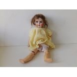 A small bisque head Armand Marseille girl doll with composition body having jointed limbs - 390m