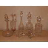 Four various decanters, a ewer and seven stoppers.