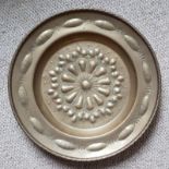 A 17thC embossed brass alms dish, decorated with a lobed flowerhead pattern to centre, 15.75".