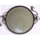 An early 20thC bronze patinated metal circular wall mirror, the plate with wide shallow bevel, on