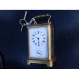 A French gilt brass alarum carriage clock, the white enamel dial with a crack and damage to upper