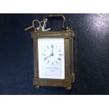 A Swiss brass carriage clock with white enamel dial retailed by Matthew Norman of London, 5" high