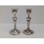 A pair of neoclassical style silver candlesticks with wryhten fluted decoration and beaded borders -