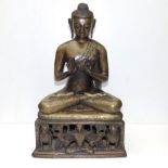 A 19thC Burmese brass Buddha, modelled sitting in the Teaching posture, supported by an openwork