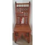 An antique Islamic chair with asymmetrical turned spindle panels.