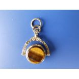 A small revolving fob seal set with tiger's eye to one side in yellow metal.
