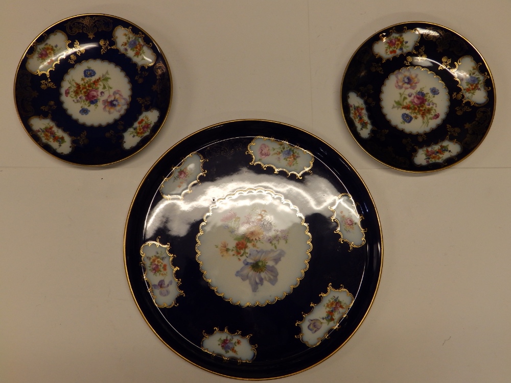 A circular Czechoslovakian porcelain tray with dark blue ground and floral decoration, 15.5" and two
