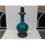A gilt metal mounted turquoise glazed art pottery table lamp, of bottle shape decorated with
