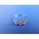 A three stone diamond ring, each claw set brilliant weighing approximately 0.35 carat on white metal