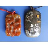 A Chinese peach jade coloured rectangular pendant relief carved to one side with flowerheads and