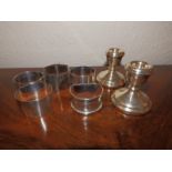 Five various silver napkin rings and a pair of modern dwarf silver candlesticks. (7)