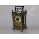 A French ornate brass carriage clock, having an openwork gilt metal surround to the circular