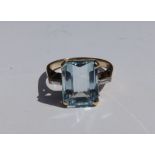 An art deco style aquamarine & diamond set 9ct gold ring, the pale step cut aquamarine weighing