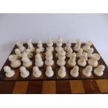 A 19thC ivory chess set, all self coloured, having only ebonised spots to differentiate opposing