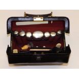 A gentleman's leather travelling toiletry case containing silver top glass bottles (one glass
