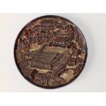 An antique Chinese red lacquered heavy wooden circular plaque/roundel, decorated in high relief to