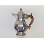 A Queen Anne Britannia Standard silver covered milk jug of octagonal baluster form, the domed hinged