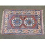 Two 20thC Oriental rugs of Caucasian medallion design, one with blue field 61" x 100", the other 34"