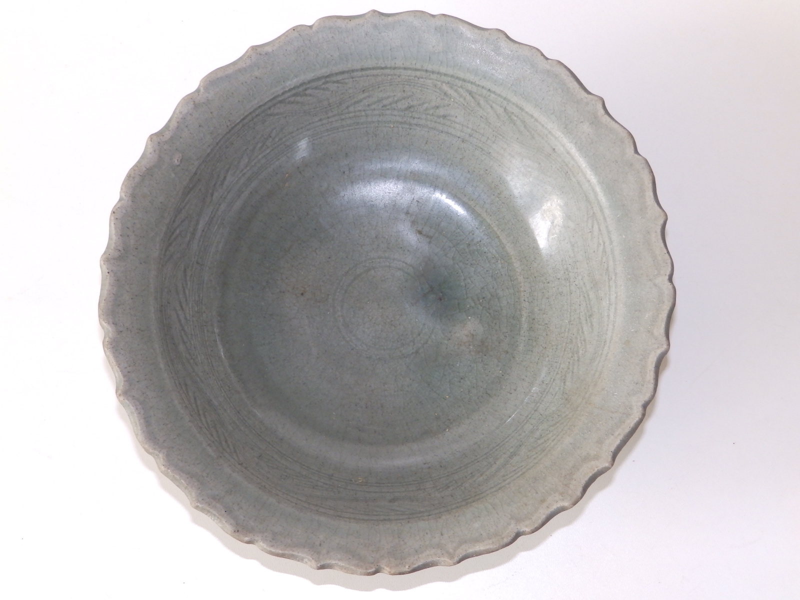 A 15thC Thai celadon glazed stoneware bowl, having lotus leaf moulded rim, a band of incised