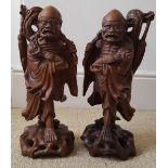 A large pair of antique Chinese carved wood figures with inlaid details for eyes and mouths, 13"