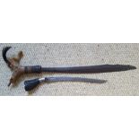 Two antique Indonesian edged weapons with carved hilts, the longer example 19" overall.