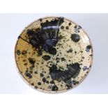A splash glazed ceramic bowl in blue on cream ground, the moulded cavetto with thin dark brown