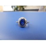 An oval sapphire & diamond cluster ring on '18ct' yellow metal shank. Finger size L.