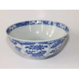A small antique Chinese blue & white porcelain bowl, decorated with flowering foliage in lappet
