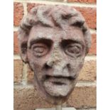 A mediaeval carved stone head, 9" high on later stone cube pedestal.