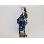 A 19thC Japanese porcelain figure of a bijin, carrying a yellow gourd over her shoulder, 11.75"