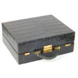 A dark green leather imitation crocodile skin toiletry case of rectangular form, the incomplete