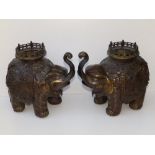 A pair of Japanese Meiji Period patinated bronze elephant incense burners, the pierced circular