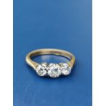 A three stone diamond ring, the central claw set brilliant weighing approximately 0.30 carat on