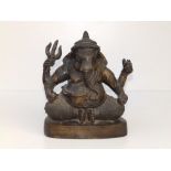 An antique Indian bronze figure of Ganesh, modelled in seated position, holding a steemit and
