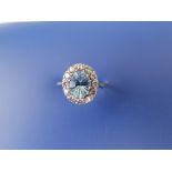 An aquamarine & diamond set 18ct white gold cluster ring, the oval aquamarine having faceted back.