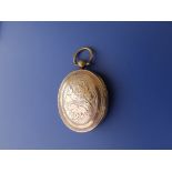 A Victorian oval locket with engraved decoration, the interior with four glazed oval mounts for