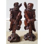 A large pair of antique Chinese carved wood figures with inlaid details for eyes and mouths, each