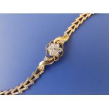 A yellow metal bracelet set with a daisy diamond cluster, tests as 18ct, 6.6".